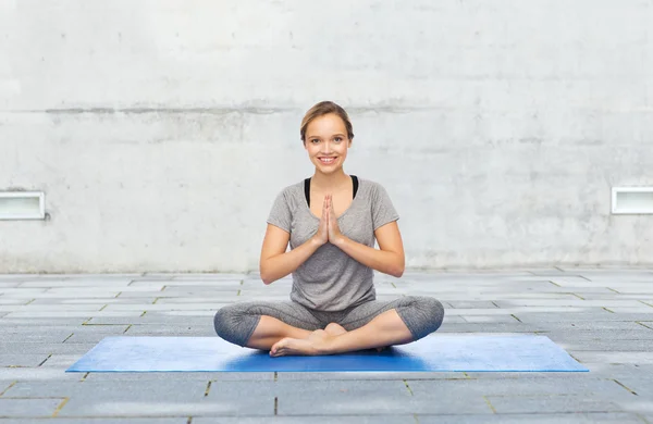 Donna che fa meditazione yoga in posa di loto sul tappeto — Foto Stock