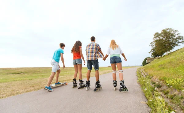 Teenagers with rollerblades and longboards — Stock Photo, Image