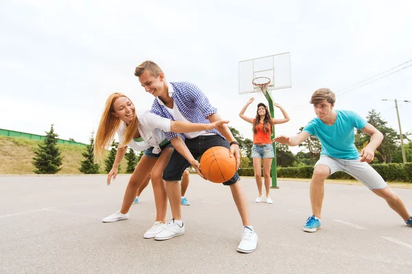 Skupina happy teenagerů hrát basketbal — Stock fotografie