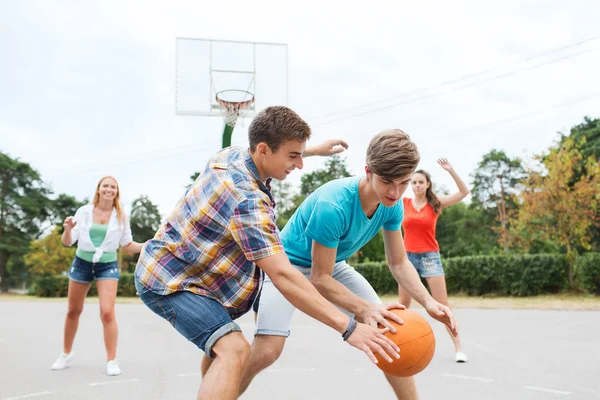 Group of happy teenagers playing basketball — Stock Photo, Image