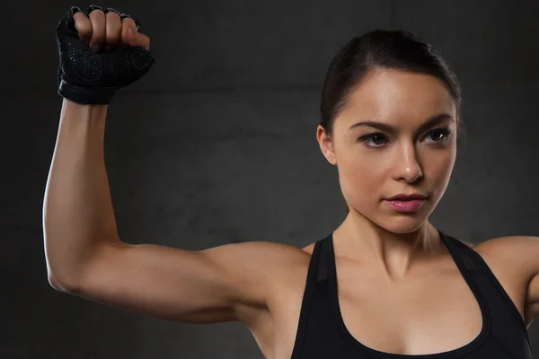 Junge Frau lässt Muskeln im Fitnessstudio spielen — Stockfoto