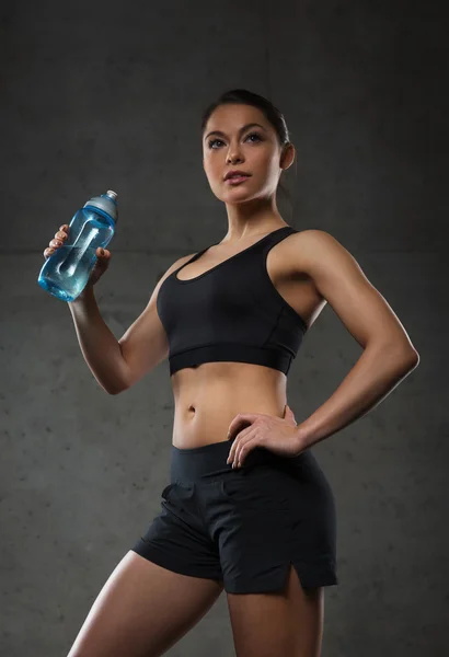 Woman drinking water from bottle in gym — Stock Photo, Image