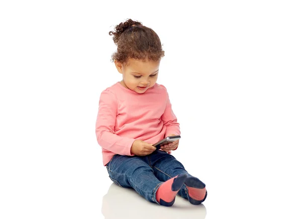 Sorrindo pequena menina brincando com smartphone — Fotografia de Stock