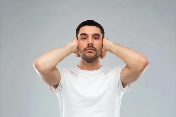 Uomo latino che si copre le orecchie con palme della mano — Foto Stock