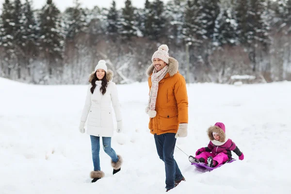 Família feliz com trenó andando na floresta de inverno — Fotografia de Stock