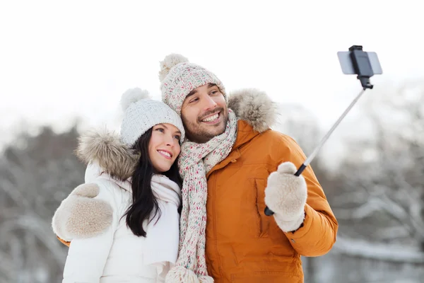 Szczęśliwa para biorąc selfie przez smartphone w zimie — Zdjęcie stockowe