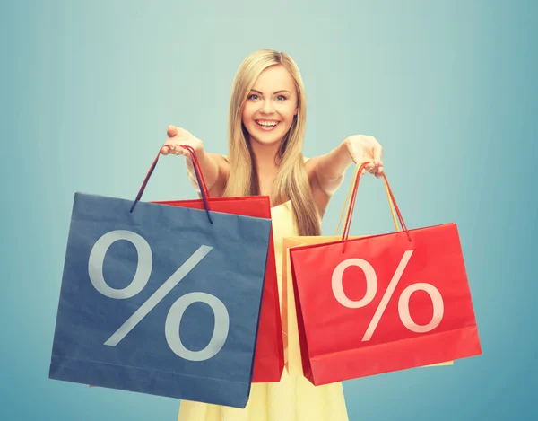 Woman holding shopping bags with percent sign — Stock Photo, Image