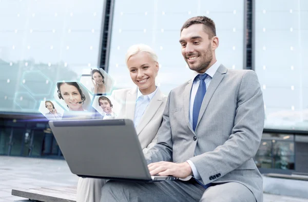 Empresários sorridentes com laptop ao ar livre — Fotografia de Stock