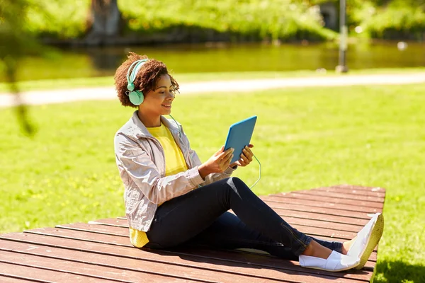 Gelukkig Afrikaanse vrouw met tablet pc en hoofdtelefoon — Stockfoto