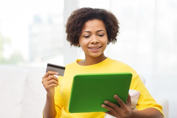 Mujer africana feliz con la PC tableta y tarjeta de crédito — Foto de Stock