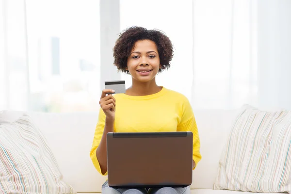 Mujer africana feliz con ordenador portátil y tarjeta de crédito —  Fotos de Stock