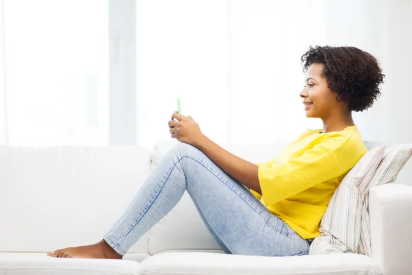 Mujer africana feliz con smartphone en casa —  Fotos de Stock
