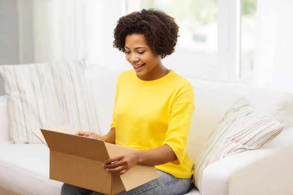 happy african young woman with parcel box at home
