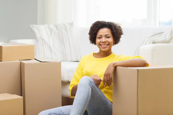 Mulher africana feliz com caixas de papelão em casa — Fotografia de Stock