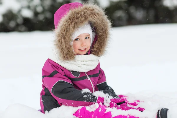 Niño feliz en ropa de invierno jugando con la nieve — Foto de Stock