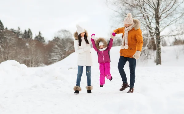 En lykkelig familie i vinterklær som går utendørs – stockfoto