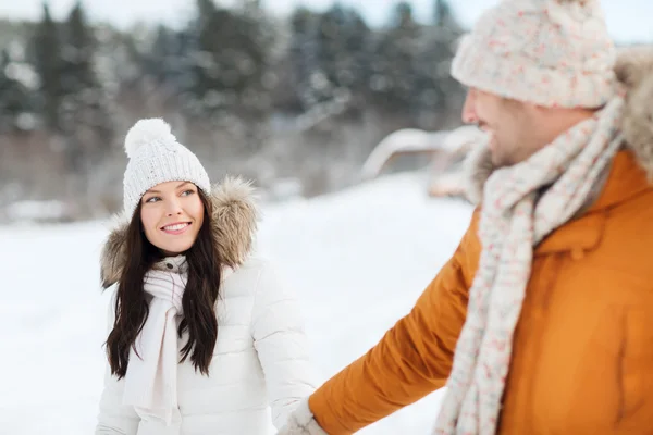 Lyckliga par promenader över vintern bakgrund — Stockfoto