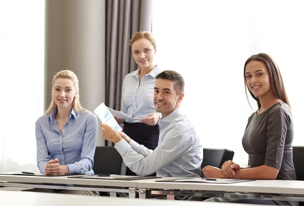 Lächelnde Geschäftsleute mit Papieren im Büro — Stockfoto