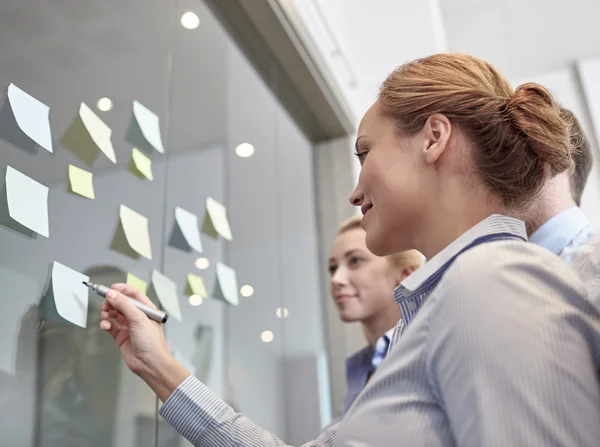 Smiling business people with marker and stickers — Stock Photo, Image