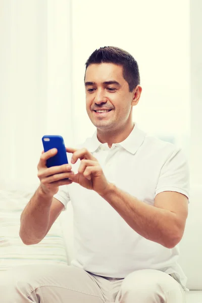 Gelukkig man met smartphone thuis — Stockfoto