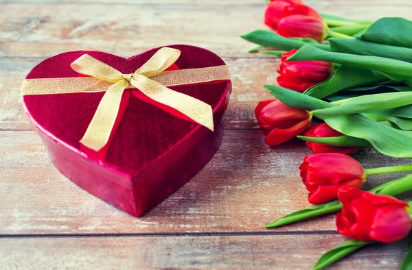 Close up of red tulips and chocolate box — Stock Photo, Image
