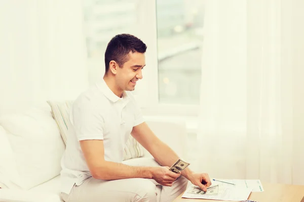 Man met papieren en rekenmachine thuis — Stockfoto