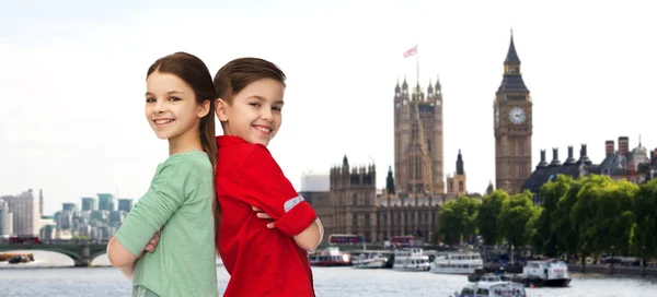 Happy boy and girl standing together over london — Stock fotografie