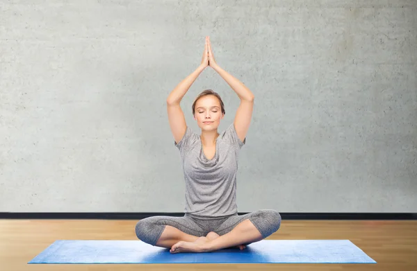 Mulher fazendo meditação de ioga em lótus posar no tapete — Fotografia de Stock