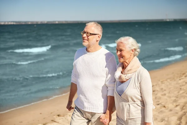Feliz pareja de ancianos caminando a lo largo de la playa de verano — Foto de Stock