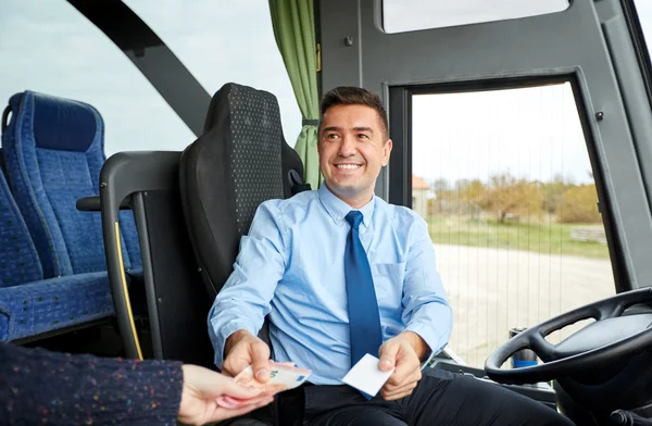 Водій автобуса з грошовим продажем квитка пасажиру — стокове фото