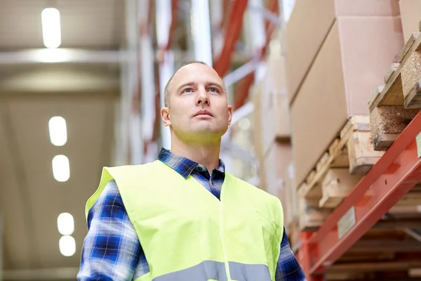 Man in reflecterend veiligheidsvest bij magazijn — Stockfoto