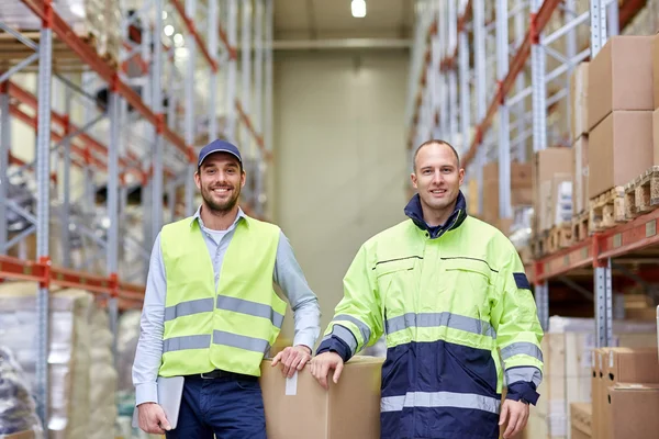 Männer in Uniform mit Kartons im Lager — Stockfoto