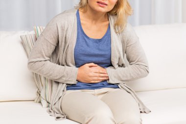 close up of woman suffering from stomach ache clipart