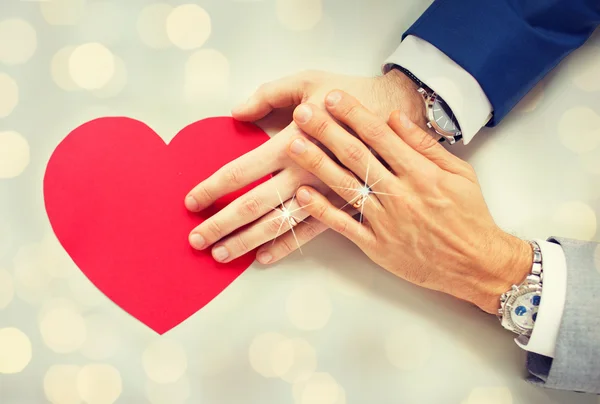 Vicino di maschio gay coppia mani con rosso cuore — Foto Stock