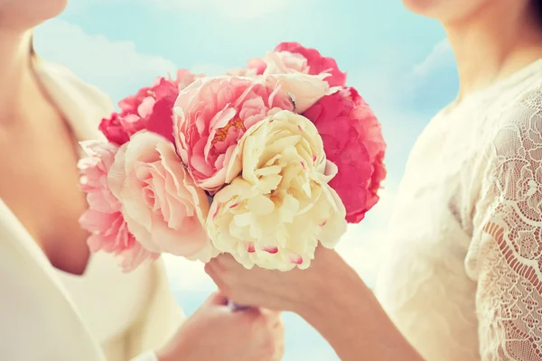 Nahaufnahme eines glücklichen lesbischen Paares mit Blumen — Stockfoto