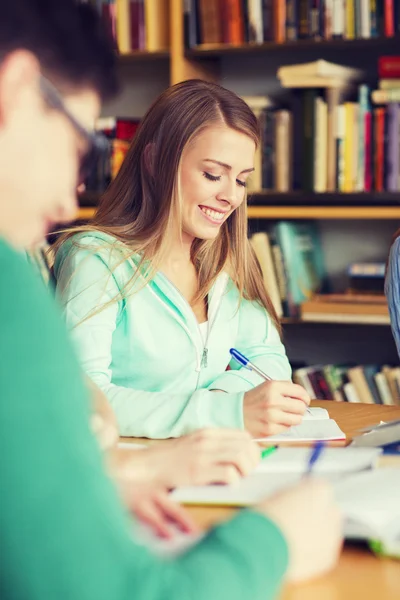 Estudiantes que se preparan para examinar y escribir en la biblioteca — Foto de Stock