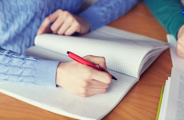 Primer plano de las manos de los estudiantes escribiendo a cuaderno — Foto de Stock