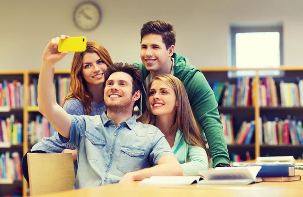 Studenci z smartphone przy selfie w bibliotece — Zdjęcie stockowe