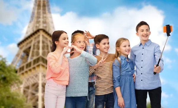 Kids and smartphone selfie stick over eiffel tower — Zdjęcie stockowe