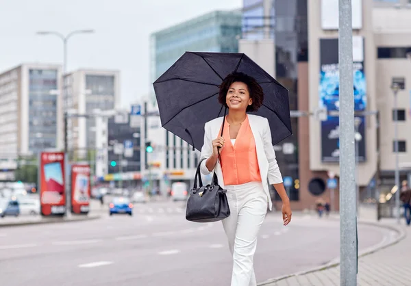 Glückliche afrikanisch-amerikanische Geschäftsfrau mit Regenschirm — Stockfoto