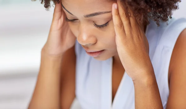 Close up of african young woman touching her head — Stock Photo, Image