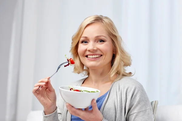 Sorridente donna di mezza età mangiare insalata a casa — Foto Stock