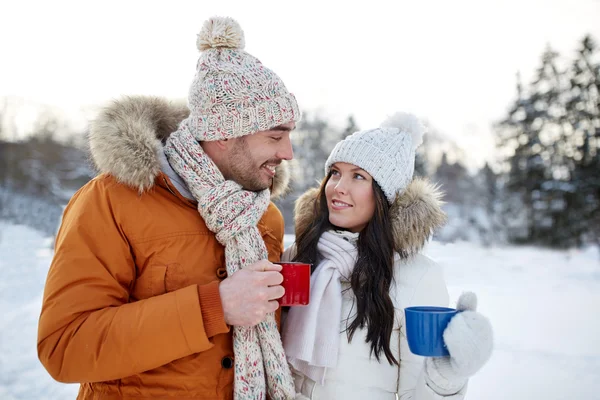 Glückliches Paar mit Teetassen über der Winterlandschaft — Stockfoto