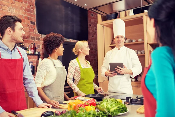 Amigos felizes com tablet pc na cozinha — Fotografia de Stock