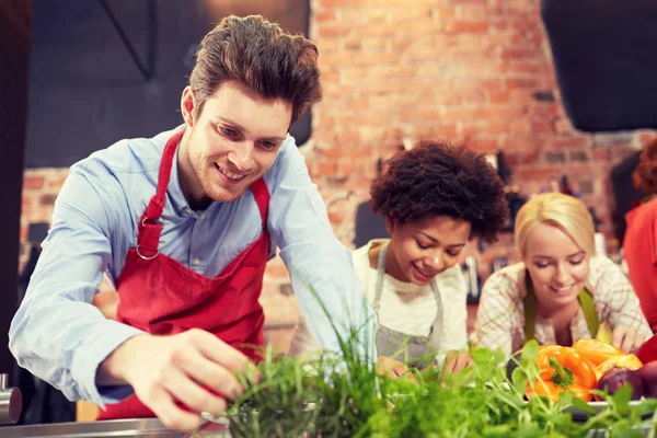 Glückliche Freunde kochen und dekorieren Gerichte — Stockfoto