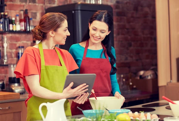 Mujeres felices con la tableta de cocina PC en la cocina —  Fotos de Stock