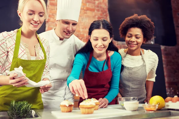 Glada kvinnor och kocken laga bakning i köket — Stockfoto