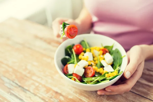 Primer plano de la mujer joven comiendo ensalada en casa —  Fotos de Stock