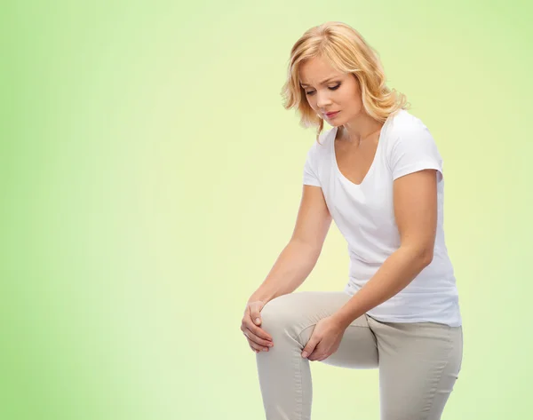 Mulher infeliz que sofre de dor na perna em casa — Fotografia de Stock