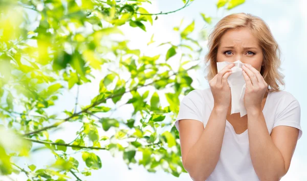 Unhappy woman with paper napkin blowing nose — Stock Photo, Image